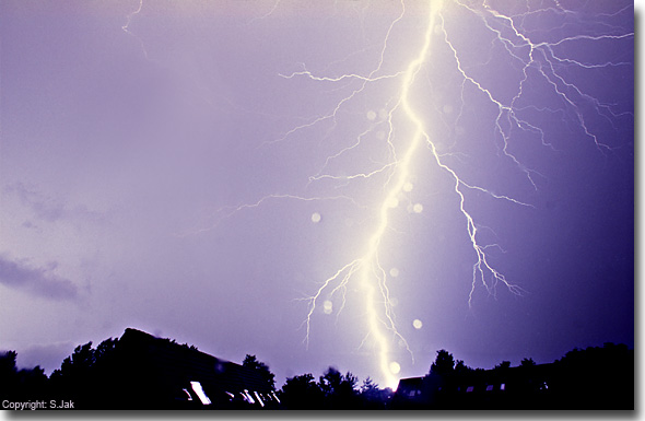 Felle bliksem-inslag op 10 juni 2007 te Bennekom, rond 23 uur. Opname met Nikon FM met 24 mm f.2.0 lens met diafragmastand f8 en een sluitertijd van enkele seconden